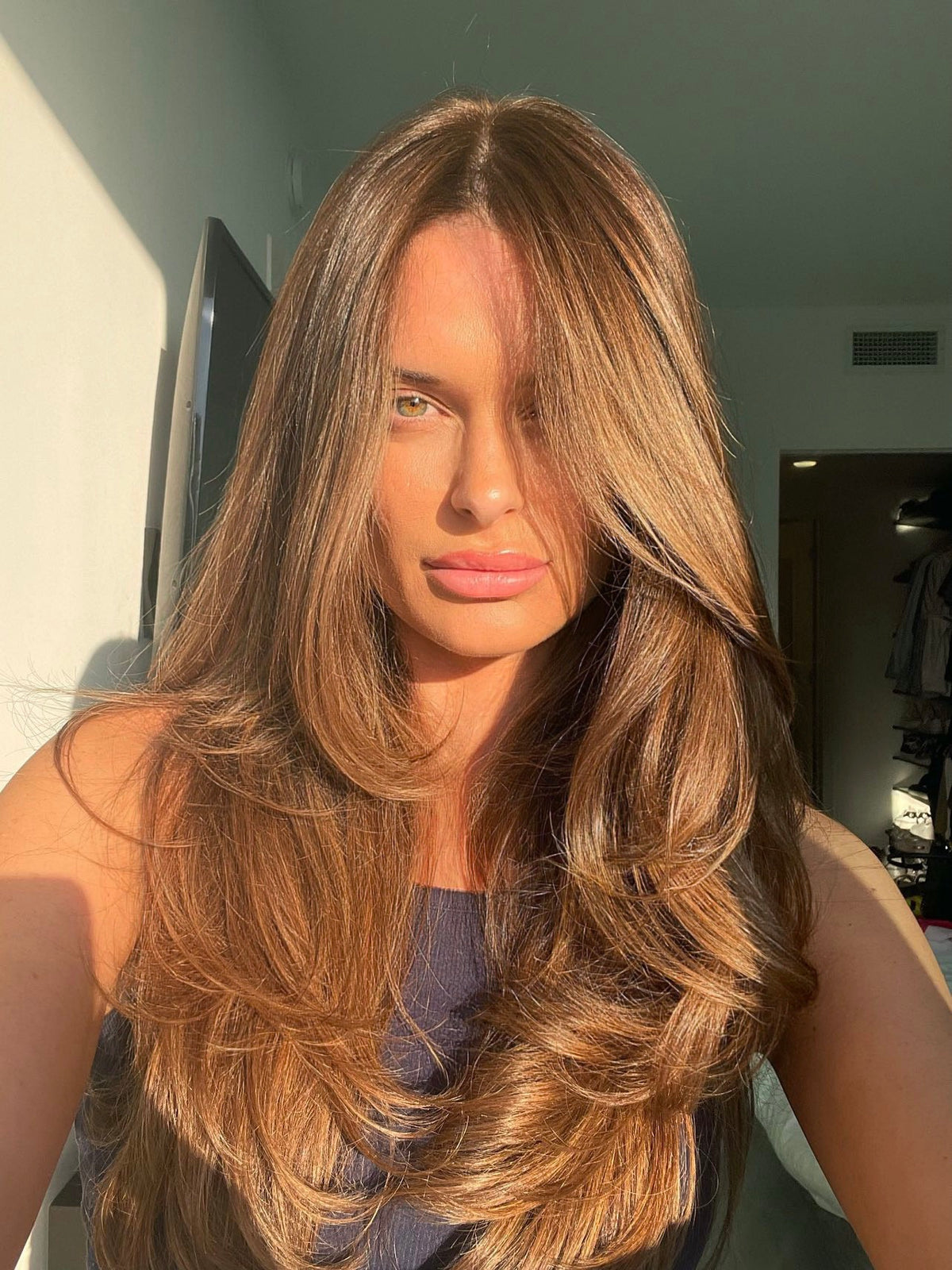 Long caramel brown layered haircut with soft face-framing