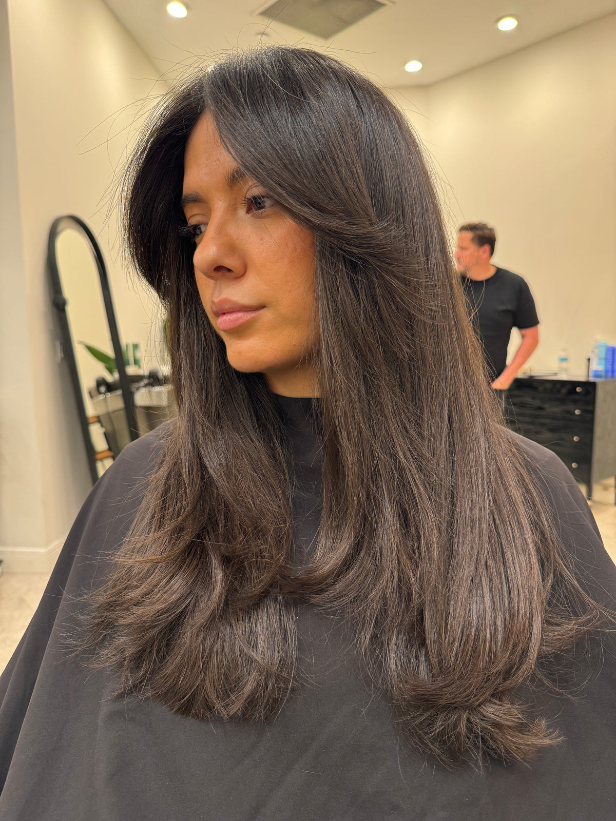 Long dark brown layered haircut, blown out smooth
