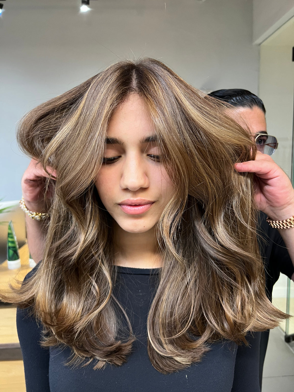 Brown hair with blonde balayage, styled in big waves
